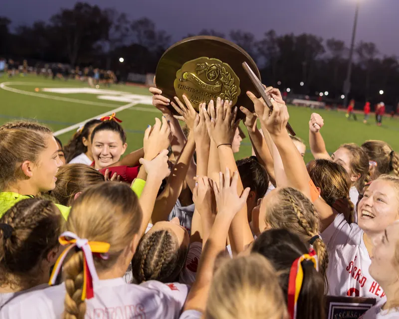 Sacred Heart Academy players lifting the championship trophy